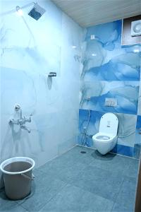 a bathroom with a toilet and a blue wall at GM hotel in Tirupati +35 photos