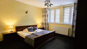 a bedroom with a bed with blue pillows and a window at Pensjonat Jastrzębia Turnia in Zakopane +135 photos