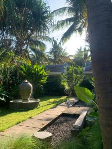 een tuin met een wandelpad en een vaas in de tuin bij Udãra Hideaway Villa in Toyapakeh