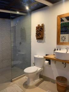 een badkamer met toilet, wastafel en douche bij Udãra Hideaway Villa in Toyapakeh +16 foto's
