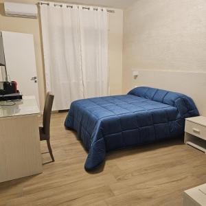 a bedroom with a blue bed and a desk at IL CENTRO rooms in Cerignola