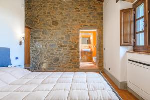 コルトーナにあるAgriturismo Podere Ponticelli - Villa con vista su Cortonaの石壁のベッドルーム1室(大型ベッド1台付)