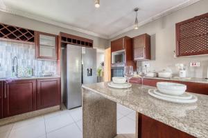 a kitchen with a counter and a refrigerator at White Rose Villa in Gaborone