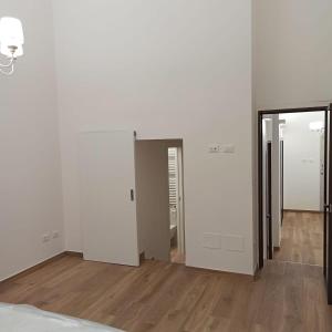 a bedroom with white walls and wooden floors and a mirror at Ionian Breeze in Taranto