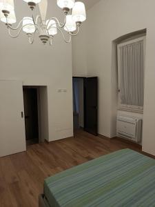 a bedroom with a bed and a chandelier at Ionian Breeze in Taranto