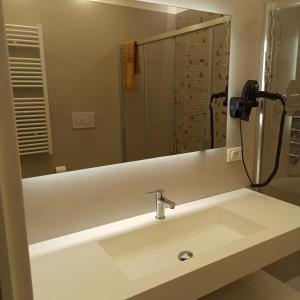 a bathroom sink with a shower and a mirror at Ionian Breeze in Taranto +2 photos