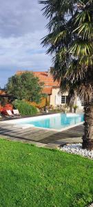 een zwembad in een tuin naast een huis bij Entre terre et baie in Pontaubault
