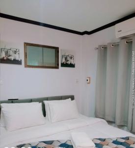 a white bed with two pillows in a bedroom at Jaydahouse hatyai in Sathani Hat Yai