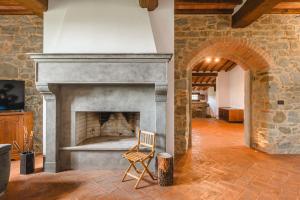 コルトーナにあるAgriturismo Podere Ponticelli - Villa con vista su Cortonaの暖炉付きの部屋の椅子