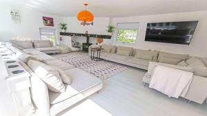 Elle comprend un salon doté d'un mobilier blanc et d'une cheminée. dans l'établissement Shippenrill Croyde - Sleeps 14 - Hot Tub option - Stylish Home with fire pit, table tennis & dog friendly, à Croyde