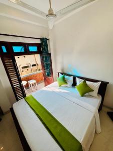 ゴールにあるSENUKiの緑をアクセントにした白い大型ベッド付きのベッドルーム1室 +42枚の写真