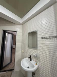 a white bathroom with a sink and a mirror at Shato Mash in Tbilisi City