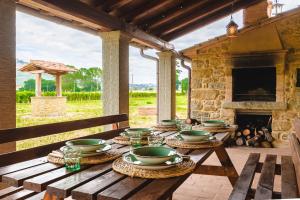 コルトーナにあるAgriturismo Podere Ponticelli - Villa con vista su Cortonaの暖炉のある木製のテーブル、その上にボウルと皿が置かれている