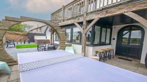 an outdoor patio with a table and chairs at Bag-End House - Unique home with Balcony, Beautiful Views, Ping Pong and Hot Tub option - Sleeps 14 in Croyde
