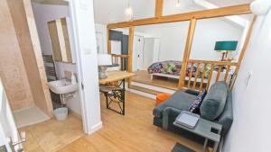 a living room with a couch and a bedroom at Bag-End House - Unique home with Balcony, Beautiful Views, Ping Pong and Hot Tub option - Sleeps 14 in Croyde