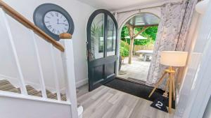 a clock is on the wall next to a door at Bag-End House - Unique home with Balcony, Beautiful Views, Ping Pong and Hot Tub option - Sleeps 14 in Croyde