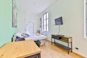 une chambre avec un lit, un bureau et une télévision dans l'établissement Le Saint Colette #Parking privé et sécurisé, à Cognac