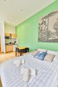 Cette chambre comprend un grand lit blanc et une table. dans l'établissement Le Saint Colette #Parking privé et sécurisé, à Cognac