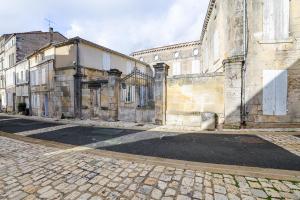 un vieux bâtiment sur le côté d'une rue dans l'établissement Le Saint Colette #Parking privé et sécurisé, à Cognac