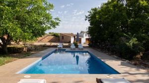 a swimming pool with two chairs and a house at Mas de Paco, Chimenea, barbacoa y piscina in Vall dʼAlba
