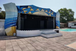 ein großes Gebäude mit einer Bühne vor einem Pool in der Unterkunft Onda Camping Village in Ardea + 31 Fotos