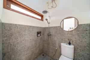 een badkamer met een toilet en een spiegel bij Jimbaran Retreat in Jimbaran