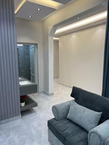 uma sala de estar com um sofá e um lavatório em تلال الفخامة em Hail