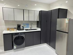 a kitchen with black and white cabinets and a dishwasher at تلال الفخامة in Hail