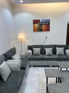 uma sala de estar com um sofá e uma mesa em تلال الفخامة em Hail