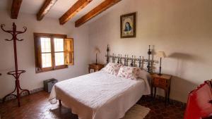 a bedroom with a bed and a window at Mas de Paco, Chimenea, barbacoa y piscina in Vall dʼAlba +16 photos