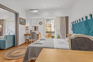 ein Schlafzimmer mit einem großen Bett und einem blauen Stuhl in der Unterkunft h2h Kalypso #Luxury, in 5' Port, in 1'metro, Airport, Athens smART, hi-tec in Piräus