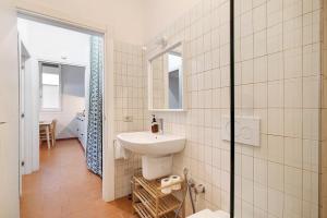 a white bathroom with a sink and a mirror at U Canetta 2 in Pietra Ligure +10 photos