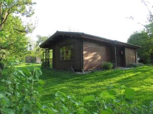 a small cabin in a yard with a green lawn at Ferienhaus Ostsee in Steinberg