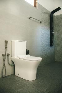 a white toilet in a bathroom with a shower at Casa Sinabowewa in Ahangama