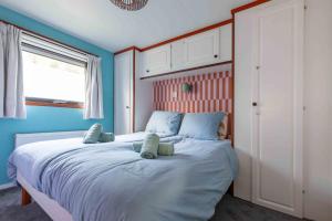 a bedroom with a large bed with blue walls at Tiny Cabin Sole op de Veluwe in Putten