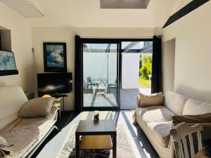 a living room with a couch and a table at La Paillote in Loctudy