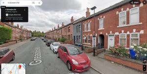 a red car parked on the side of a street at 3-Bed House Near M1 & Meadowhall with Free Parking in Sheffield
