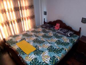 un lit dans une chambre avec une serviette jaune dessus dans l'établissement Nature's peak Udawalawa, à Uda Walawe