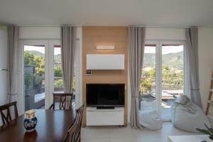 un soggiorno con TV a schermo piatto e ampia finestra di Luce Di Mare ad Alassio