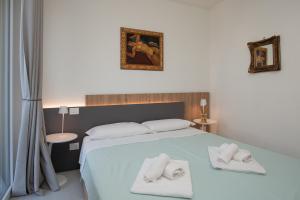 una camera da letto con un letto con due asciugamani sopra di Luce Di Mare ad Alassio Altre 27 foto