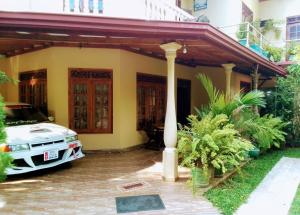 une voiture garée devant une maison dans l'établissement Nature's peak Udawalawa, à Uda Walawe