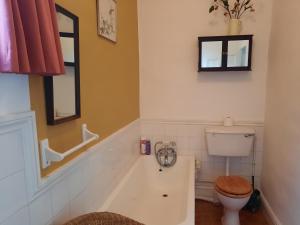 a bathroom with a toilet and a bath tub at Cosy Bath-tub Ensuite in Wickwar