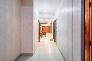 pasillo con paredes blancas y suelo de baldosa blanca en FabHotel Novis House, en Noida