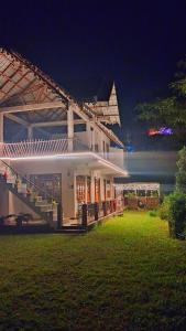una gran casa blanca con césped delante en Sittong Farmstay, en Kurseong