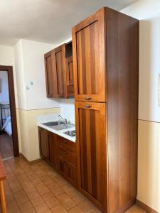 eine Küche mit Holzschränken und einer Spüle in der Unterkunft Assisi, Acutis apartments in Assisi