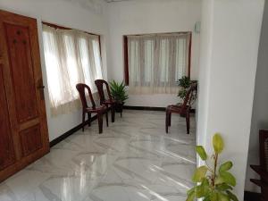 a room with chairs and a door and windows at White Shell in Tangalle