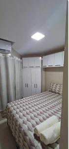 a bedroom with a large bed with white cabinets at Maison Chateaubriand Residence in Maceió