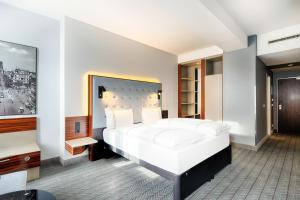 een slaapkamer met een groot wit bed en een tv bij Premier Inn Köln City Mediapark in Keulen