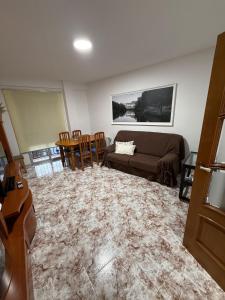 ein Wohnzimmer mit einer Couch und einem Tisch und Stühlen in der Unterkunft Exclusivo Apartamento COFRENTES in Cofrentes