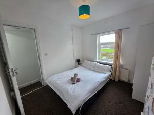 a bedroom with a white bed with a candle on it at Inviting 3-Bed Home in Worksop with Street Parking in Creswell